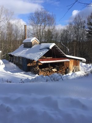 Sugar house surrounded by snow.