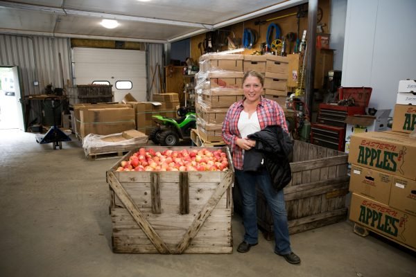 Brady Shearer stands with a bin of newly harvested apples.