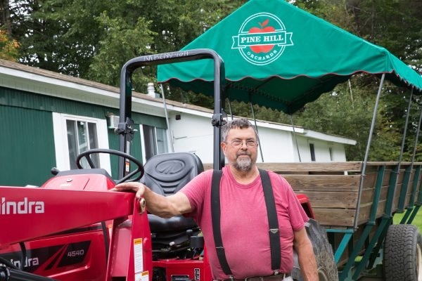 Owner-operator, David Shearer, stands with his tractor set up with a wagon for fall visitors.