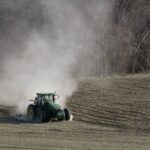 A tractor kicks up a cloud of dust as a farmer turns over this dry field in Gill in November. STAFF FILE PHOTO/PAUL FRANZ